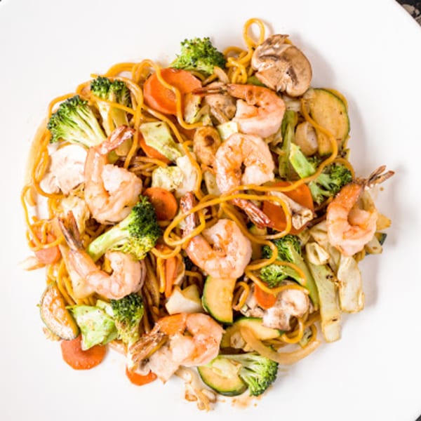 Nori Teriyaki Mukilteo's shrimp yakisoba with noodles, broccoli, carrots, zucchini, and mushrooms on a white plate.