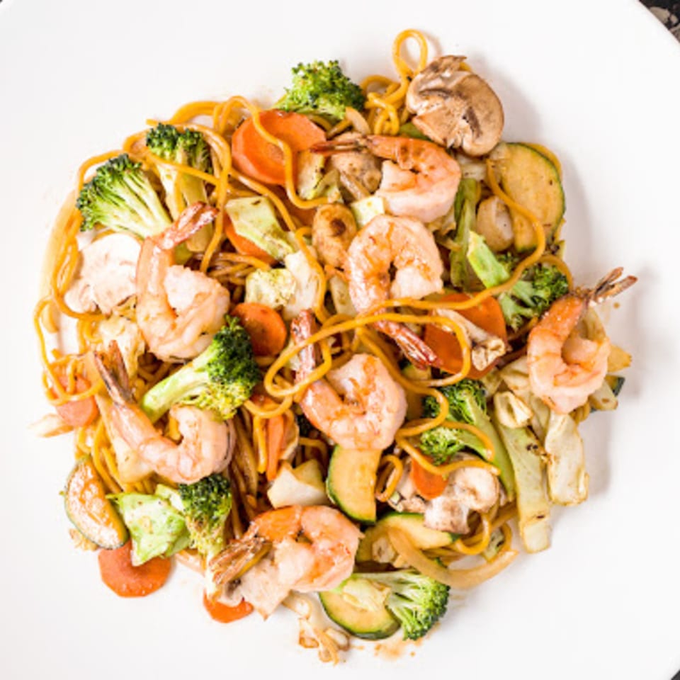 Nori Teriyaki Mukilteo's shrimp yakisoba with noodles, broccoli, carrots, zucchini, and mushrooms on a white plate.