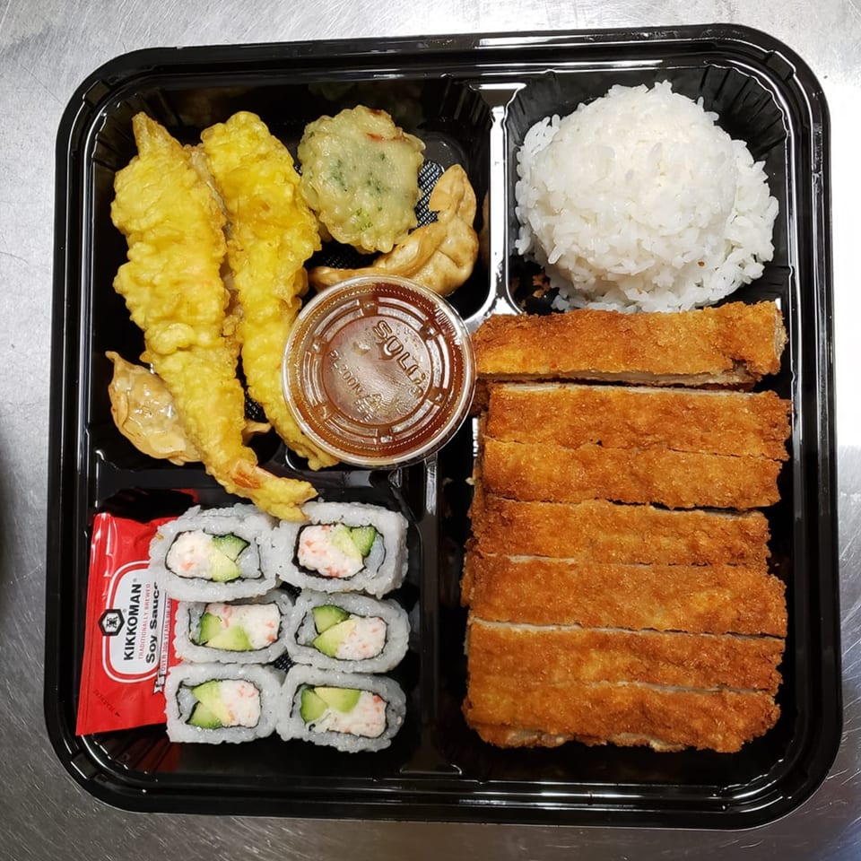 Nori Teriyaki Mukilteo bento box with tempura, gyoza, rice, tonkatsu, and California rolls.