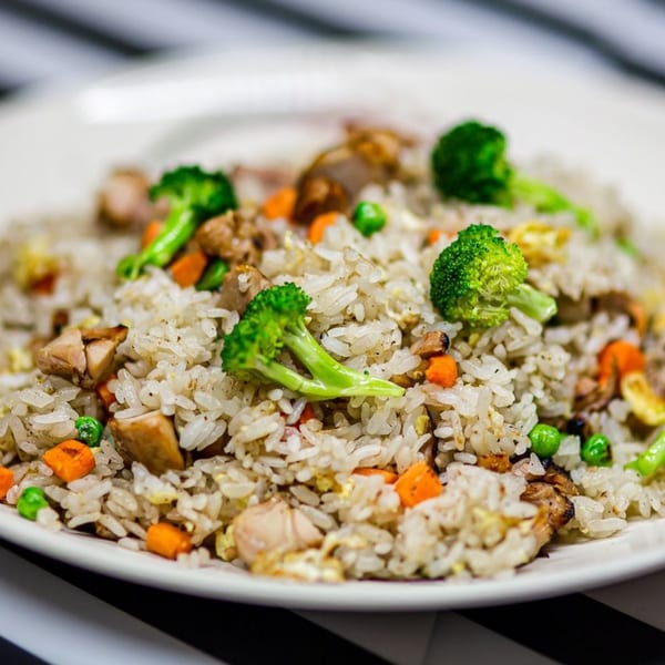 Close-up of Nori Teriyaki Mukilteo's chicken fried rice with broccoli, carrots, and peas.